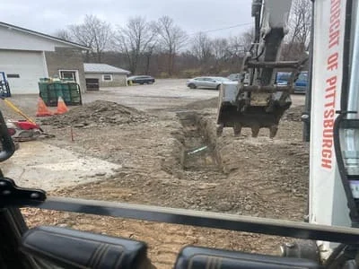 Excavator grading and moving soil on residential site preparation project