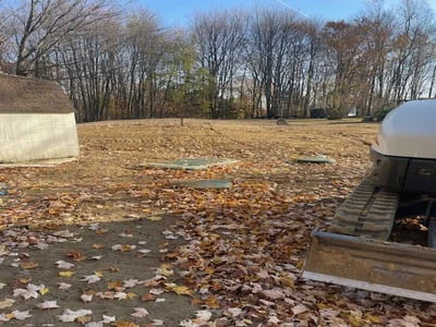 Cleared and graded excavation site with removed topsoil and debris, bare earth preparation